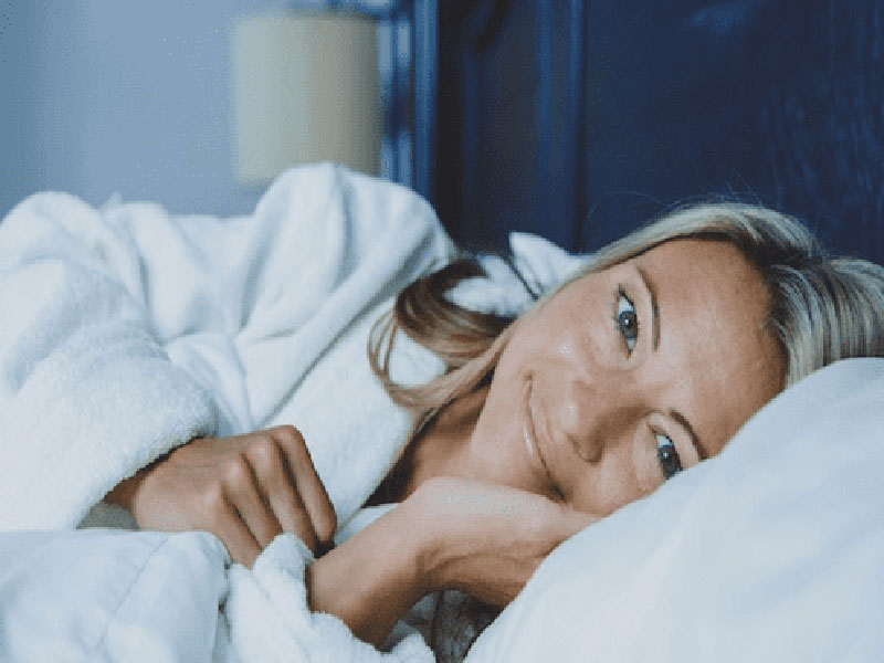 A women smiling while lying in the bed